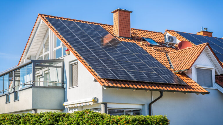 Solar panel combined with dual inverter compressor, combination of air conditioner compressor and heating pump, installed on a roof of family house.
