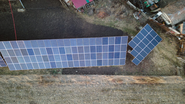 Solar photovoltaic panels mounted on stand-alone frame on backyard ground for generating of clean ecological electric energy. Concept of autonomous house.
