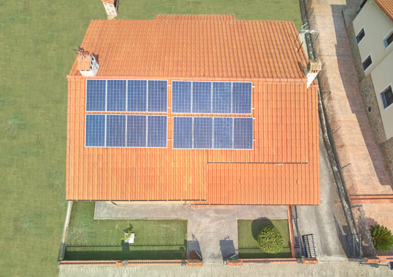 Aerial view of a house with solar panels on the roof.